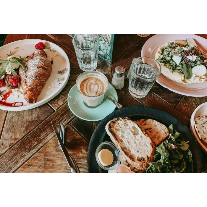 plats pour un repas avec café posé sur une table avec un verrse d'eau