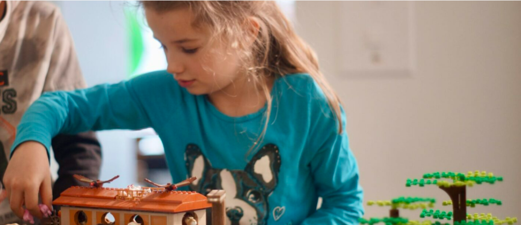 enfant qui joue à construire avec des blocks de constructions type Lego.