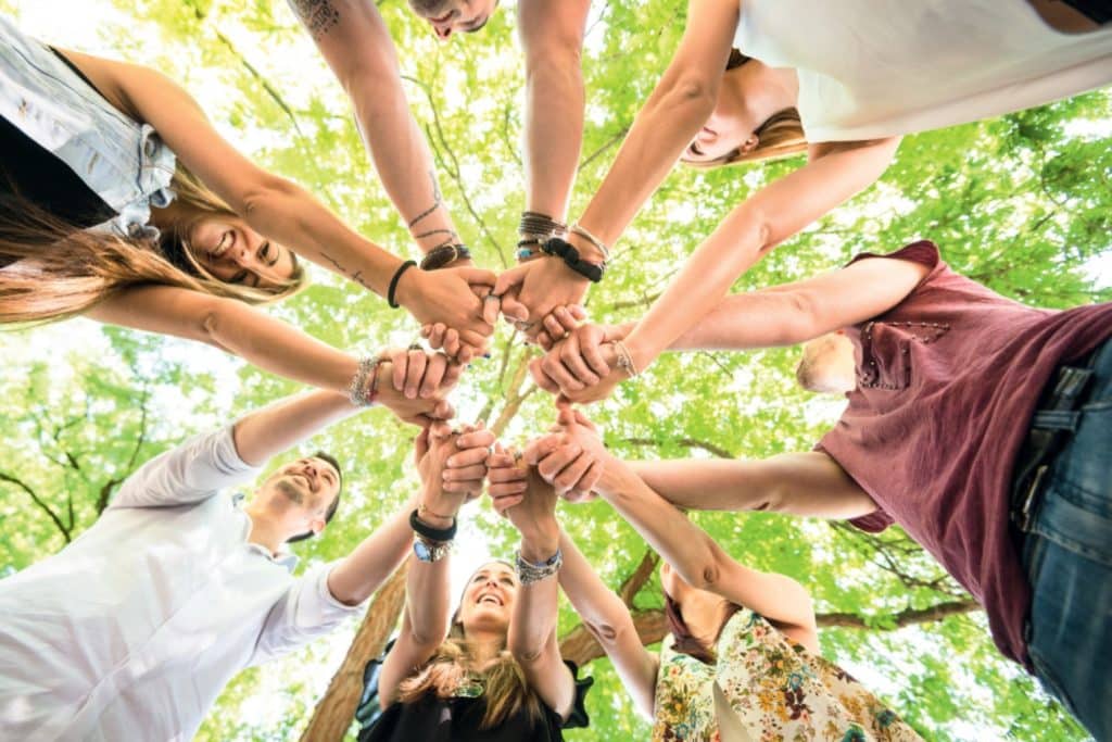 groupe de personnes joyeux qui se tiennent la main. symbole de l'unité