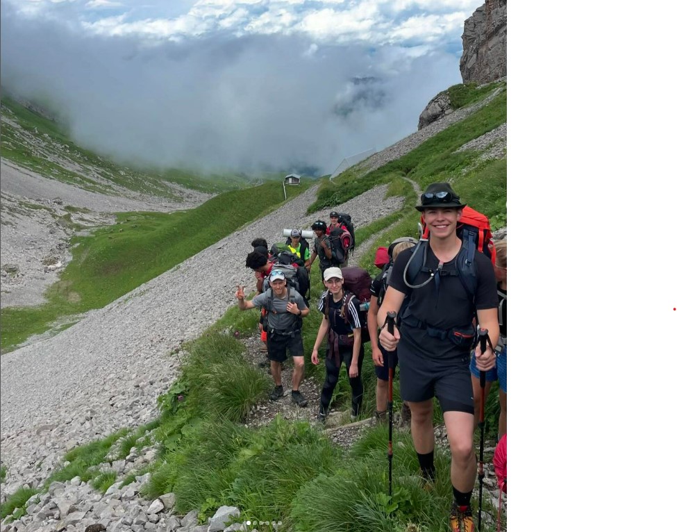 campers on a hiking trip in the mountains during a day excursion at a summer vacation youth camp