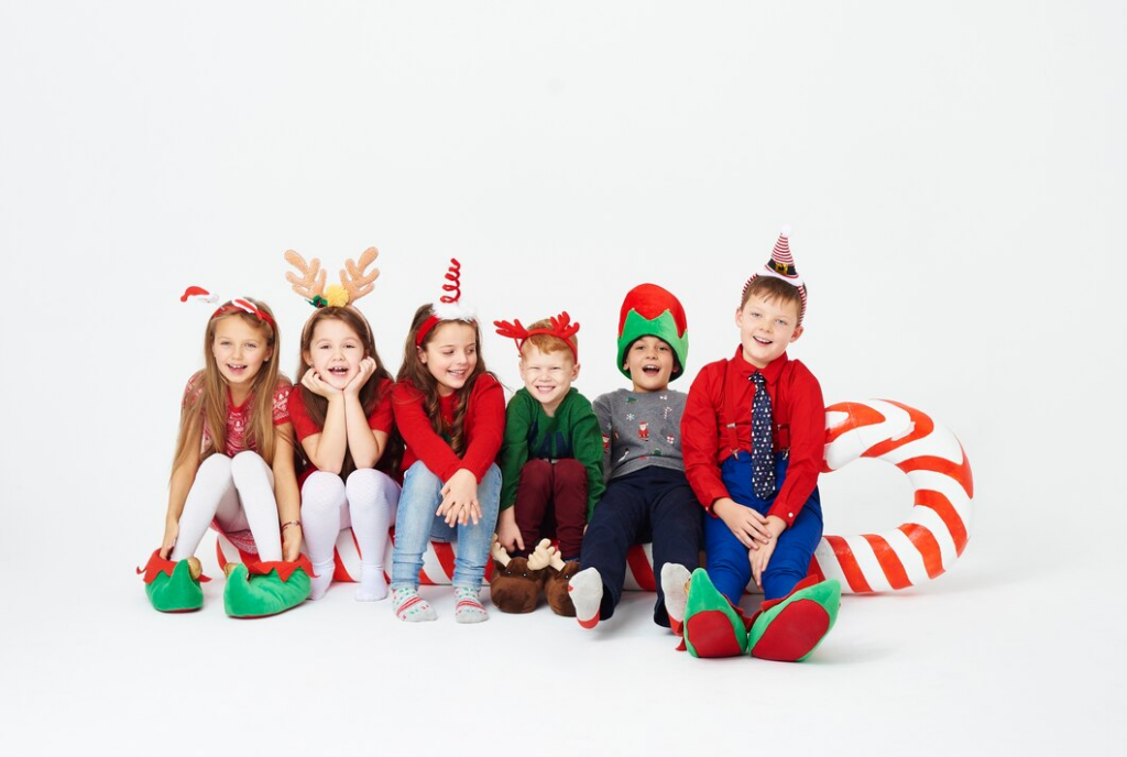 groupe d'enfants souriants dans un cadre décoré de Noël pour symboliser le groupe d'enfants Lausanne-Renens qui se rencontrent avant Noel.